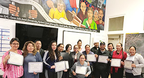 A picture of a group of people showing off graduation certificates