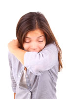 Photo of a woman coughing into her sleeve