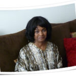 Delaine smiling, sitting on a couch