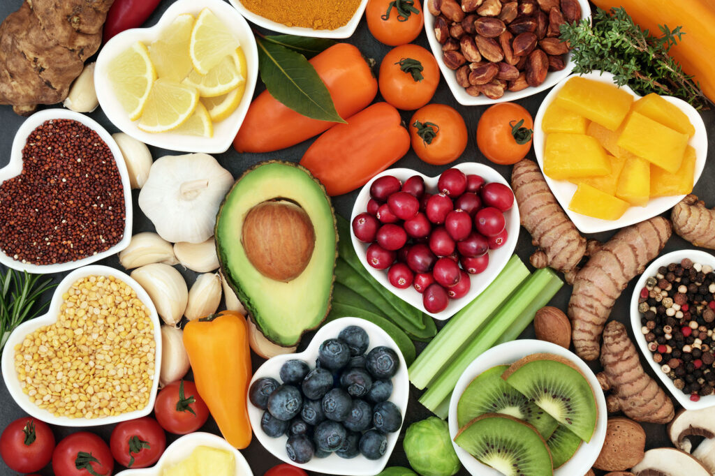 Heart shaped bowls filled with fresh fruit, vegetables, herbs, spices, nuts, grains and pulses.