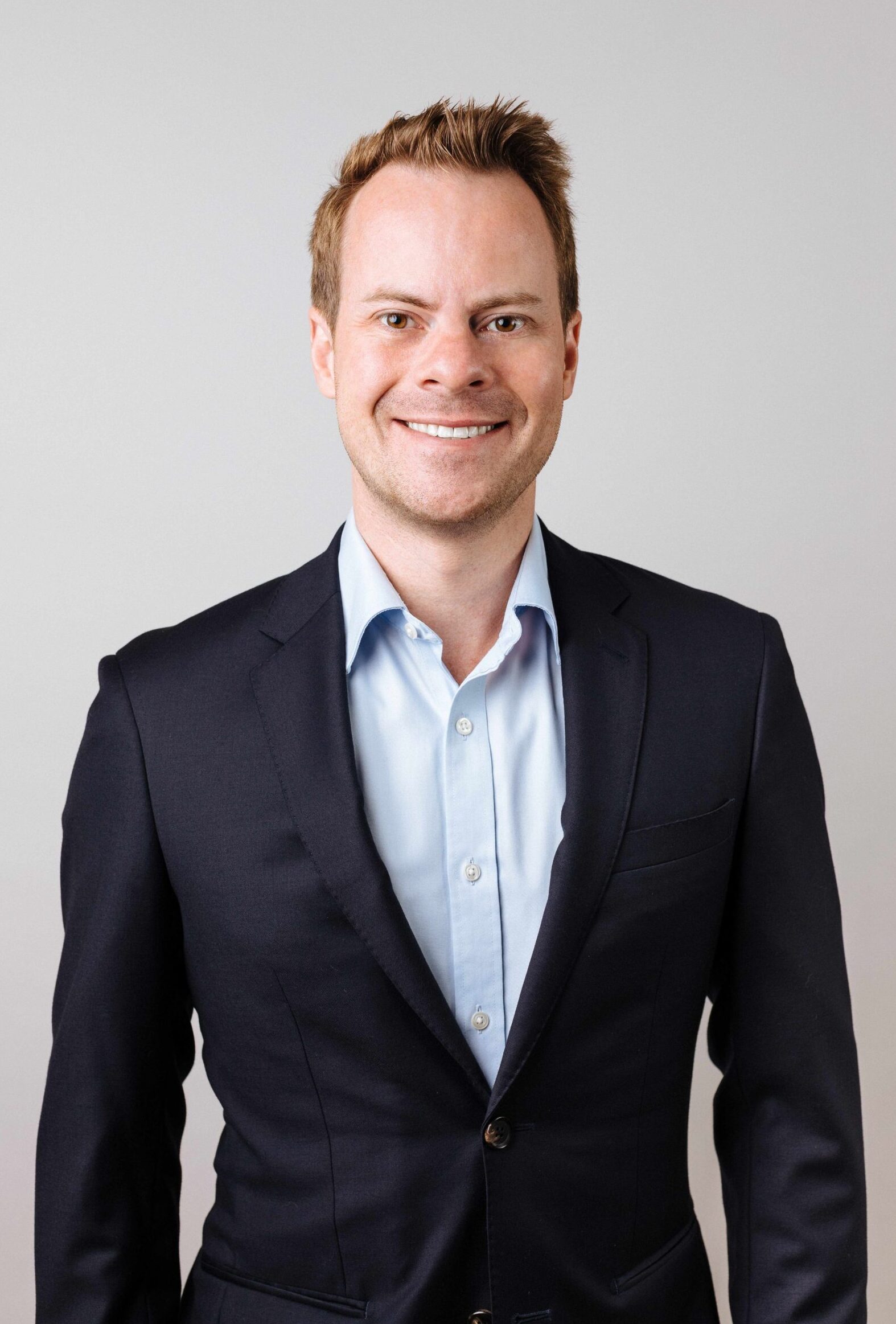 Profile image of Nick McBride wearing a blue shirt and dark blue jacket.