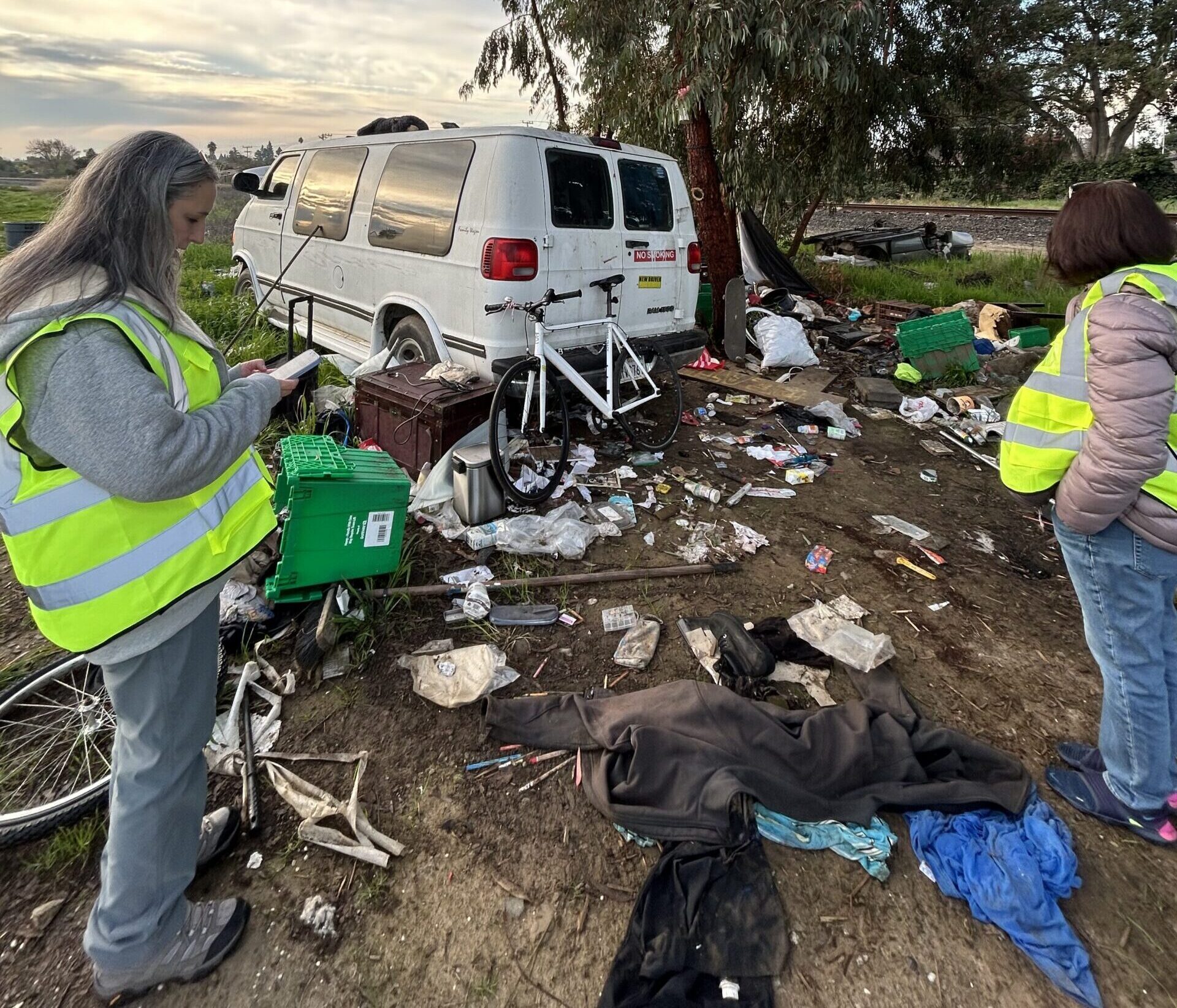 Image of volunteers wearing yellow vests and working at an encampment.