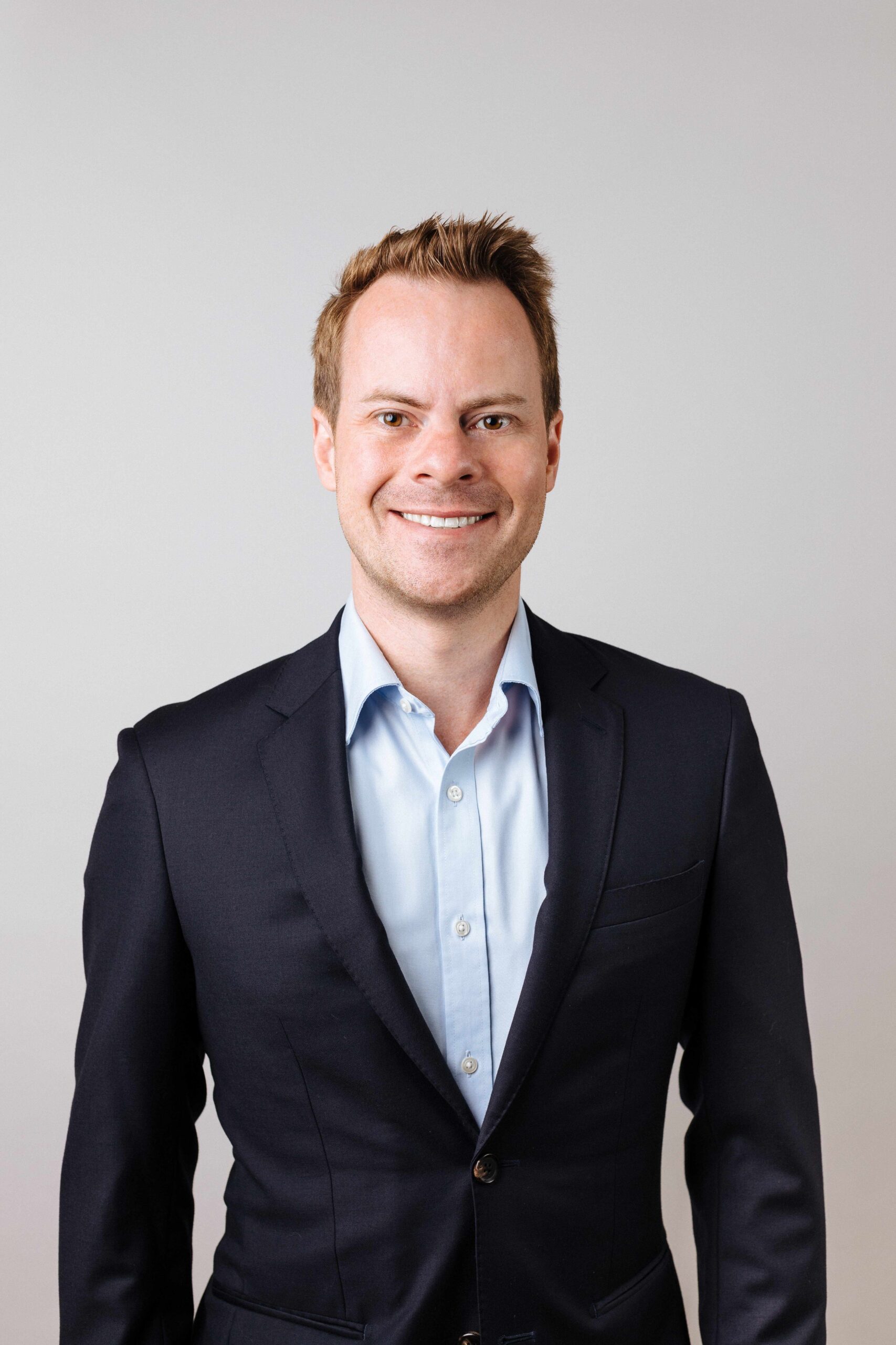 Profile image of Nick McBride wearing a blue shirt and dark blue jacket.
