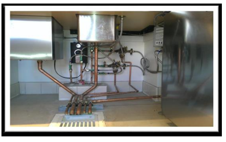 A photo shows plumbing routed beneath commercial equipment